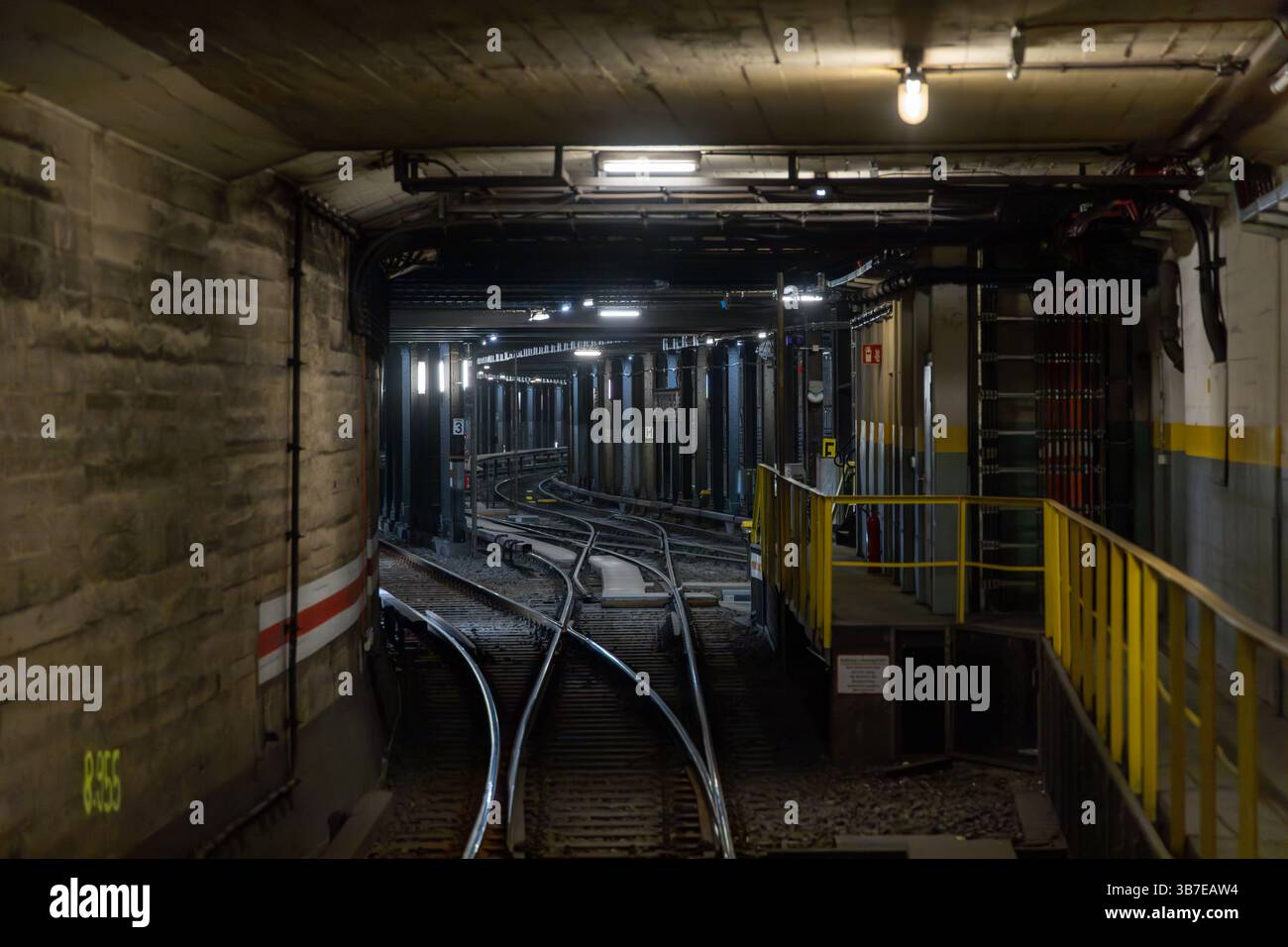 Tunnel ferroviaire souterrain à Berlin avec interrupteurs de voie complexes et éclairage industriel. Une vue cachée de l'infra technique du métro urbain Banque D'Images