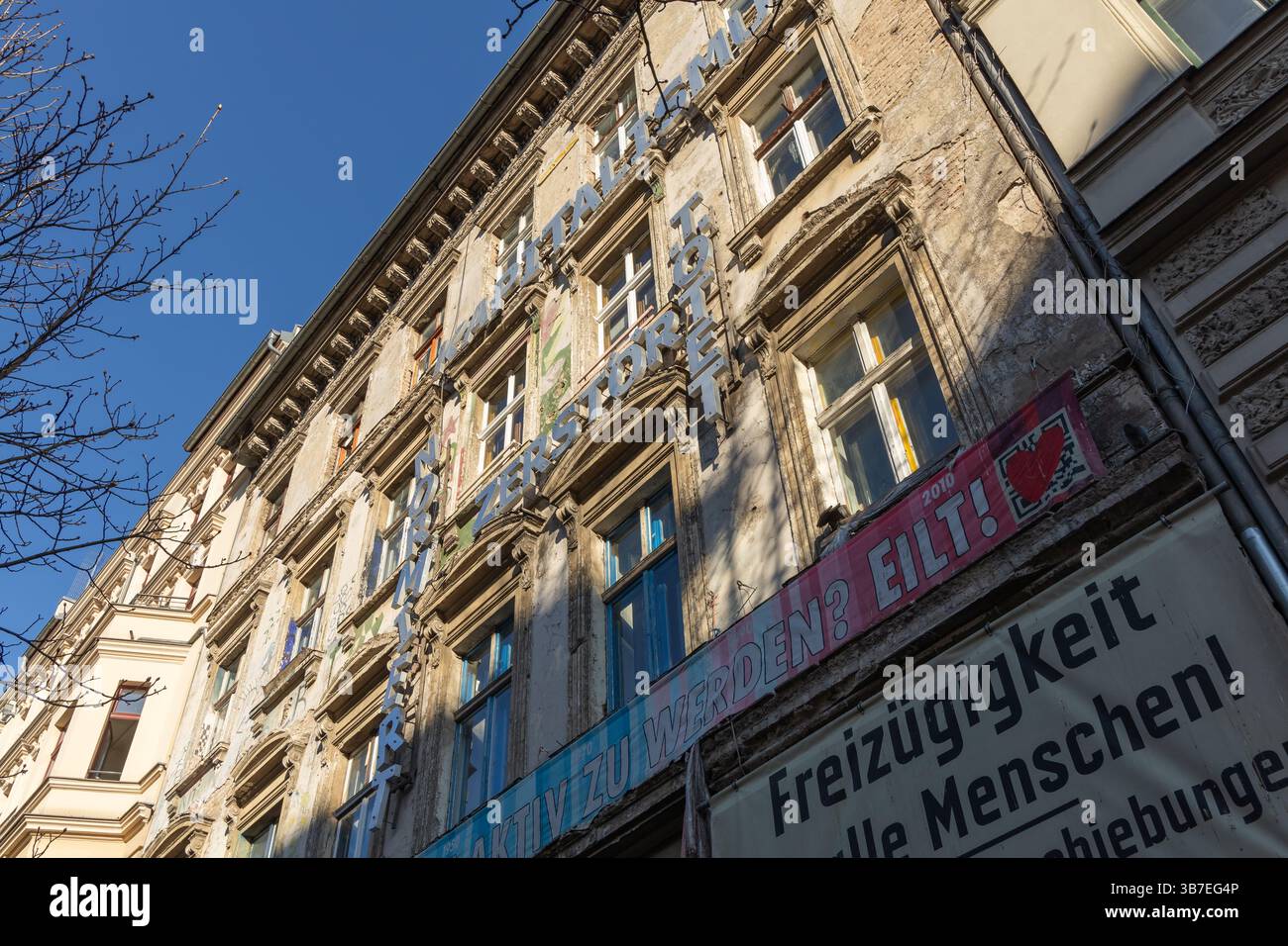 Ancien bâtiment résidentiel avec des banderoles de protestation et des slogans à Berlin, en Allemagne, symbolisant l'activisme politique, la crise du logement et la résistance sociale. B Banque D'Images