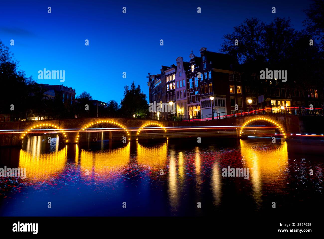 Intersection Keizersgracht et Leidse canal Reflections nocturnes. L'architecture historique et les canaux avec des stries de lumière la nuit à Amsterdam. Banque D'Images