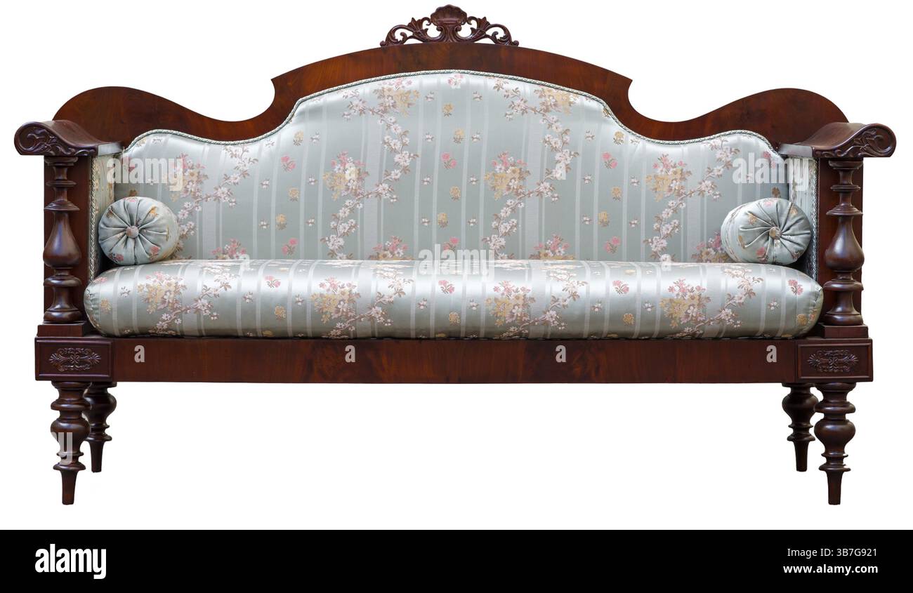 Ce canapé présente des bras et des jambes en bois ornés, ornés de tissus d'ameublement à motifs floraux, créant une charmante esthétique vintage parfaite pour le classique Banque D'Images