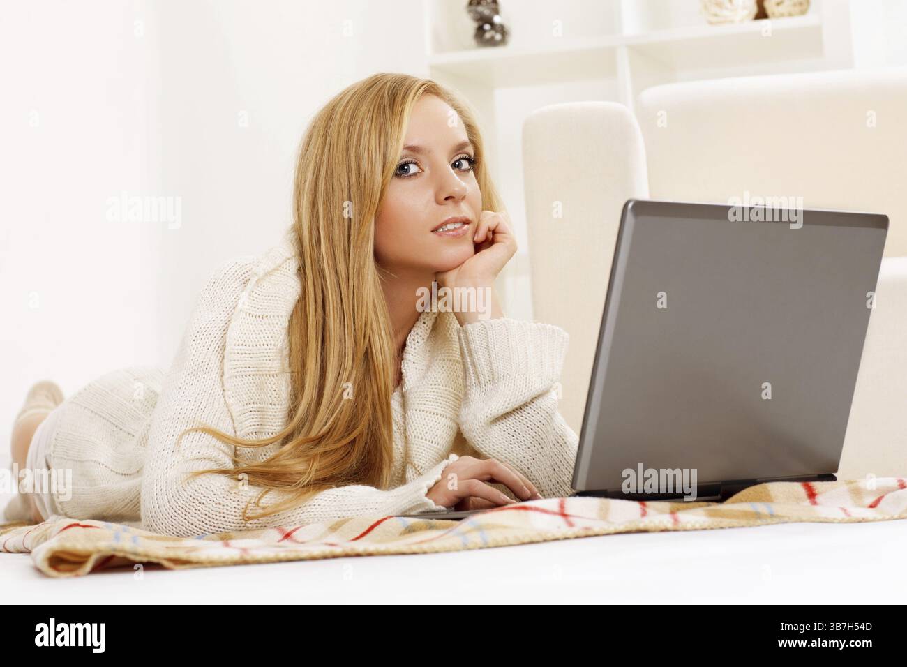 Fille de beauté avec ordinateur portable dans la chambre Banque D'Images
