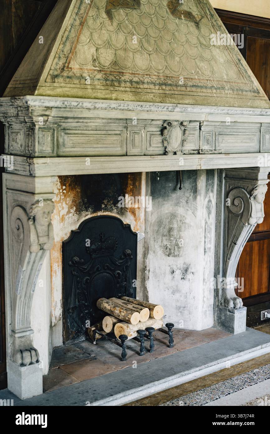 Ancienne cheminée dans la maison. Une ancienne cheminée dans la maison avec des colonnes et des bas-reliefs. Banque D'Images