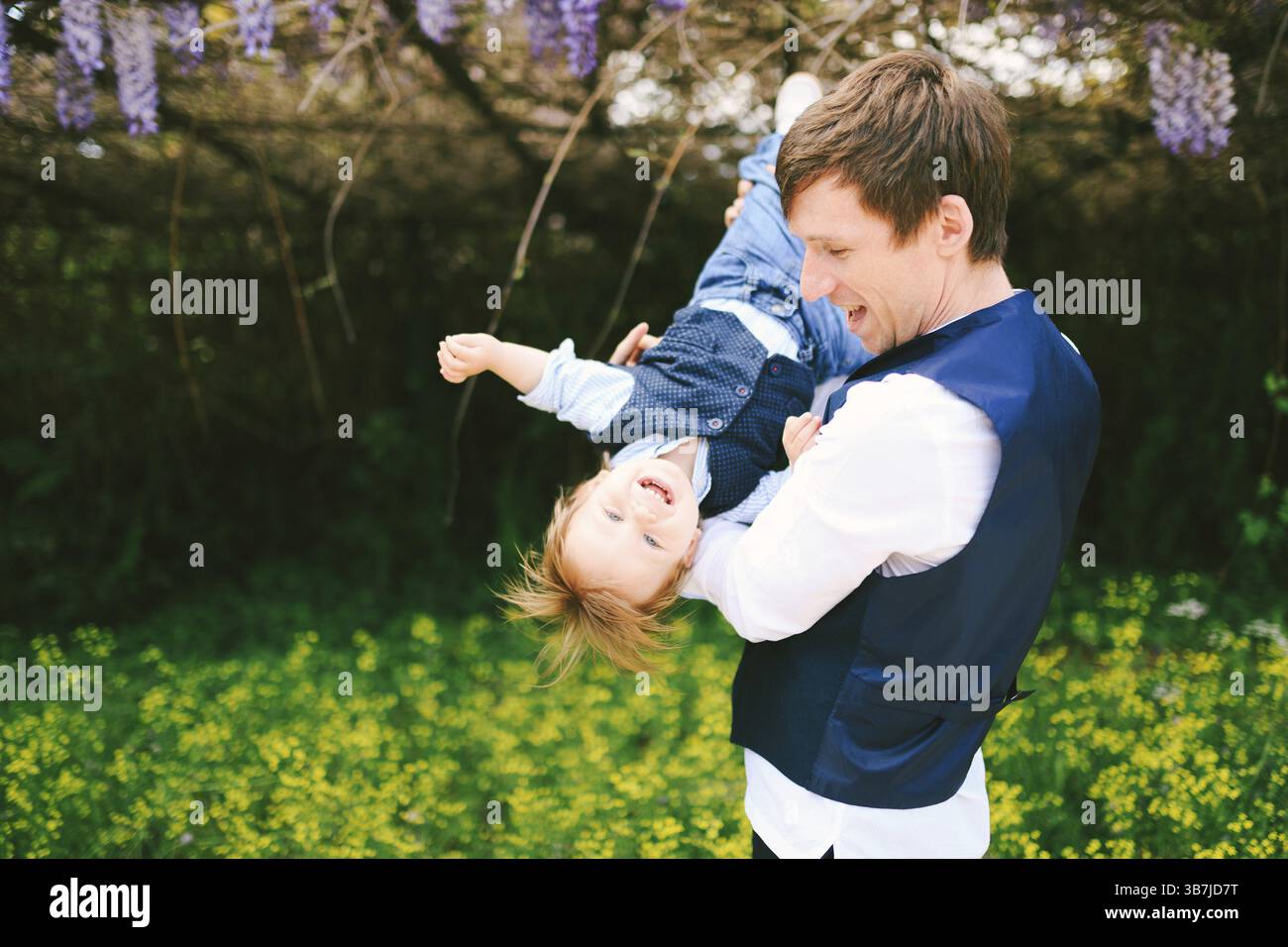Père s'amuse avec son fils dans le parc par une journée ensoleillée. Banque D'Images