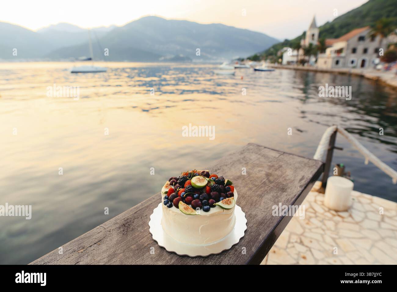 Gâteau de mariage de figues, cerises et baies avec une crème blanche. Sur la table dans un café sur la plage Banque D'Images