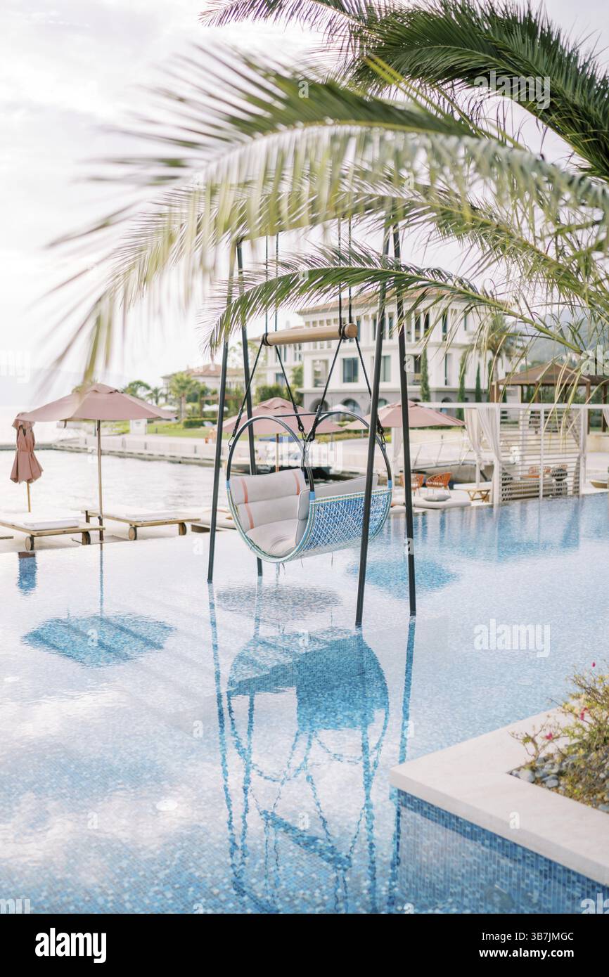 Chaise suspendue sur des stands dans la piscine d'un complexe hôtelier. Banque D'Images