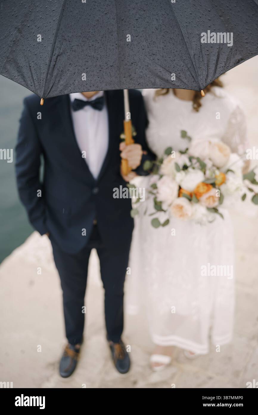Gouttes de pluie sur un parapluie sur la mariée et le marié. Flou. Gros plan. Banque D'Images