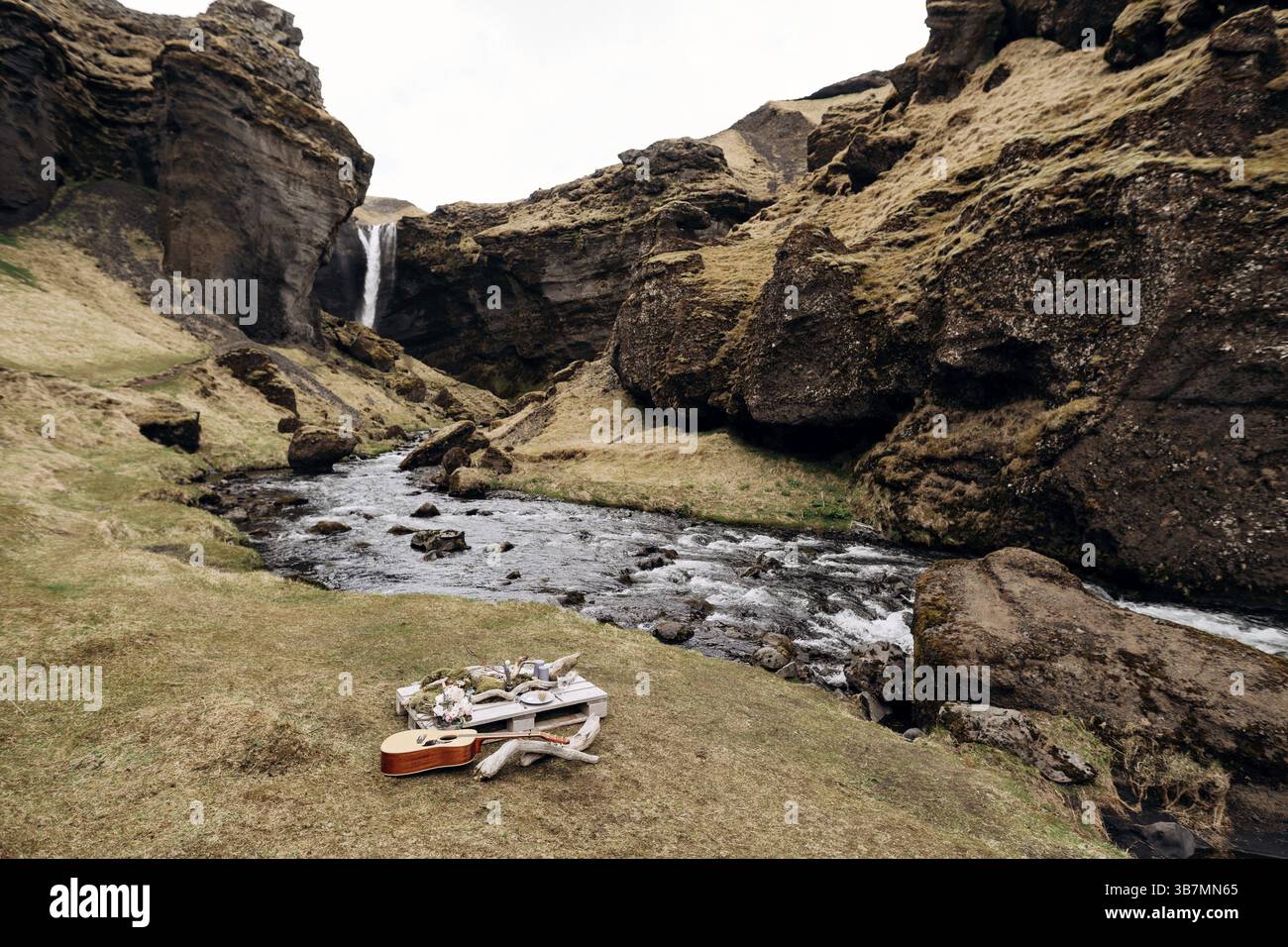 Une table de mariage impromptue pour deux sur les rives de la montagne, sur l'herbe en Islande. Une table de palette de construction décorée de bois flotté et omi Banque D'Images
