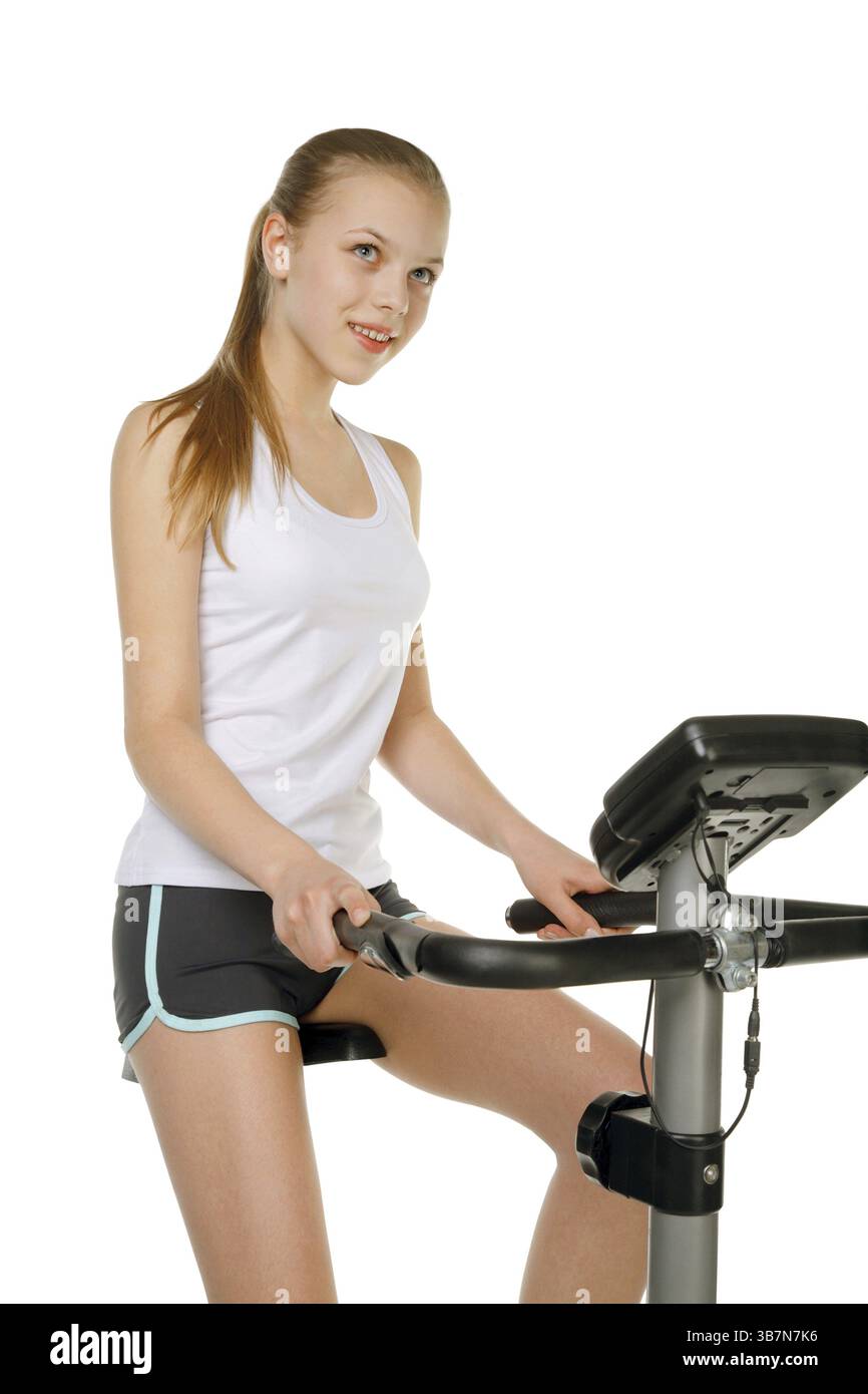 Fille de beauté avec machine de vélo de gymnastique Banque D'Images