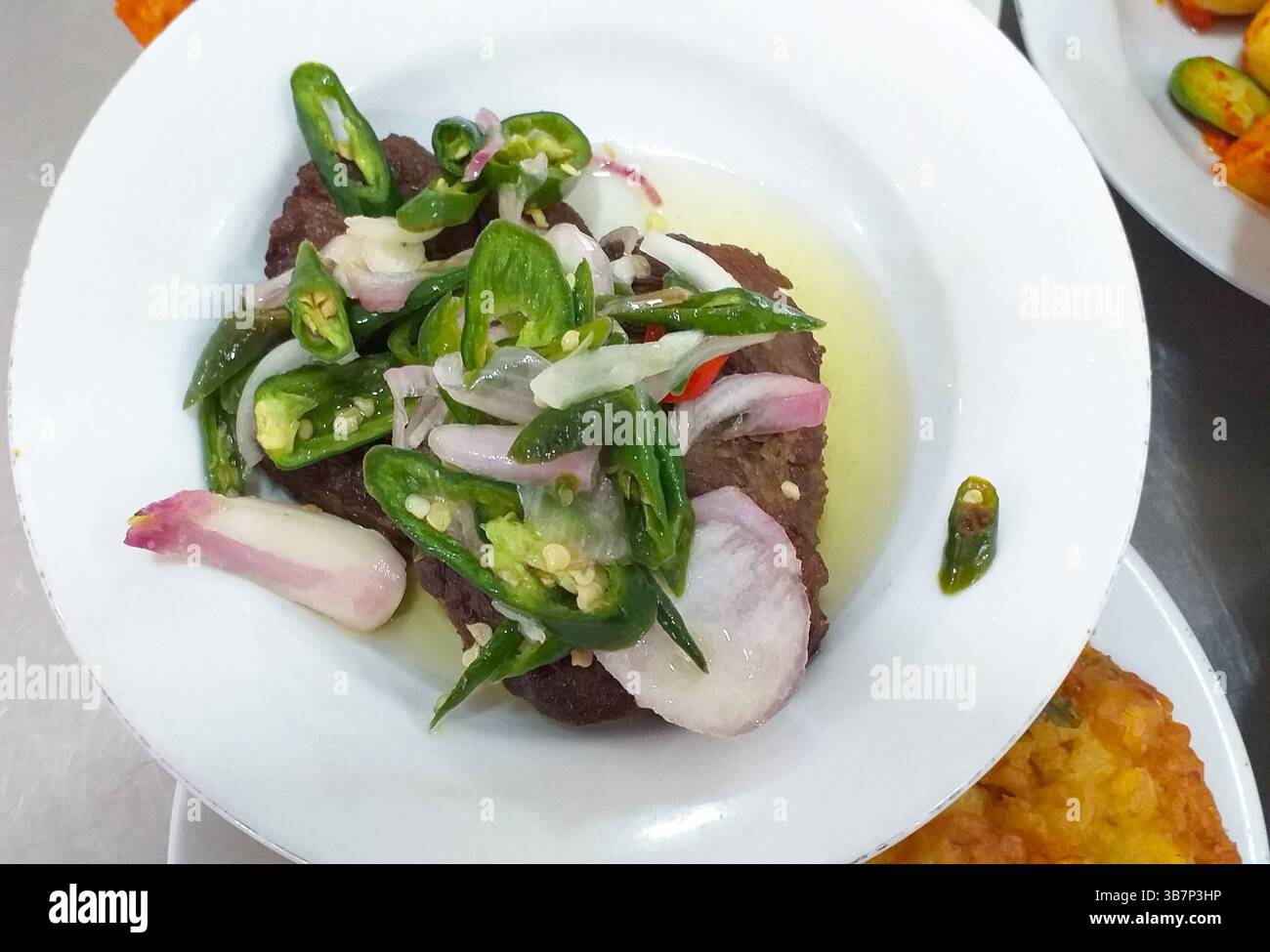Dendeng batokok ou dendeng cabe hijau, un plat indonésien de Sumatra occidental. C'est du bœuf séché servi avec de l'huile de noix de coco, du piment vert et de l'échalote Banque D'Images