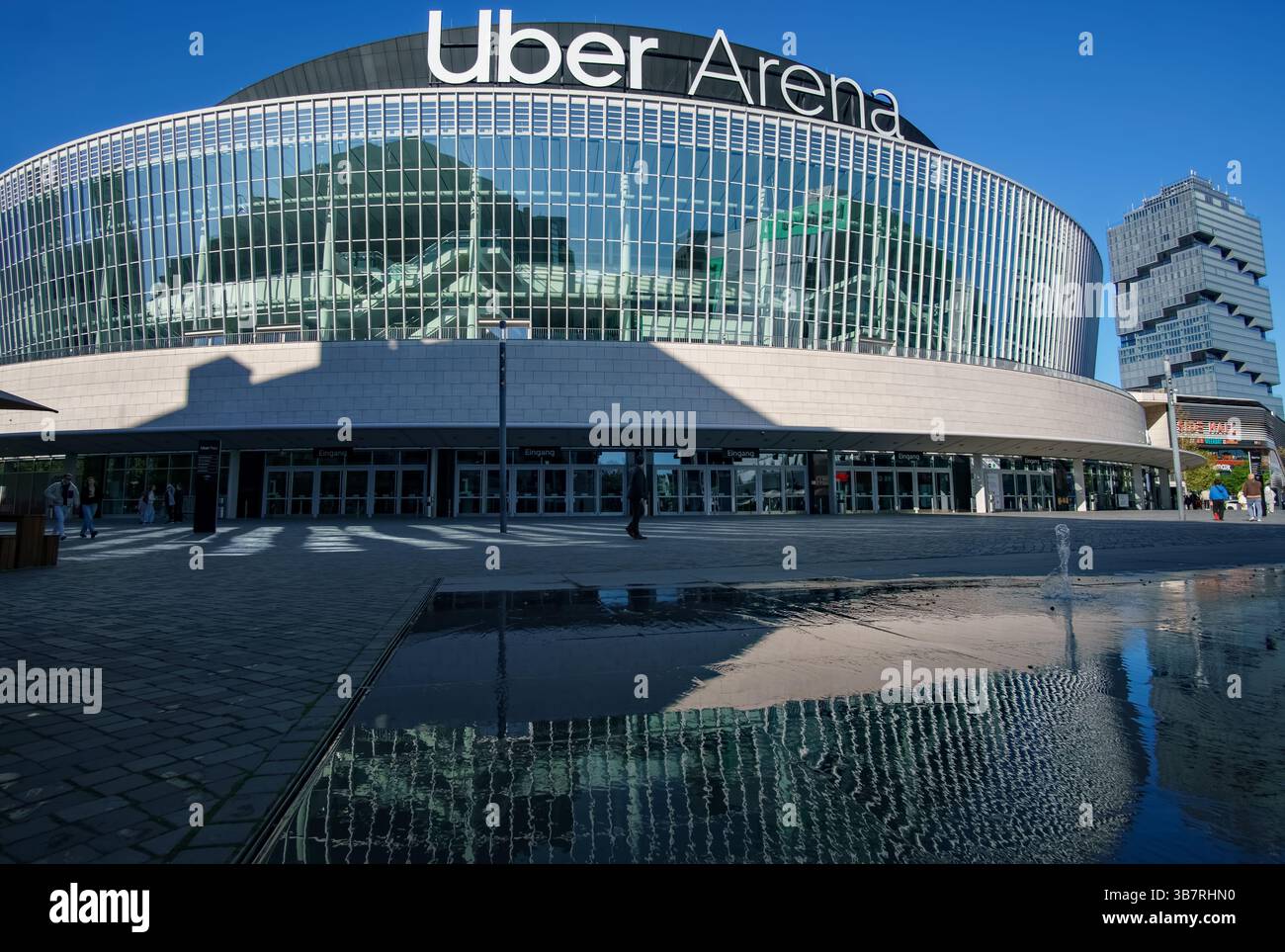 Vue sur l'Uber Arena de Berlin, Allemagne, avec une architecture moderne et des reflets de plaza sous le soleil printanier. Banque D'Images