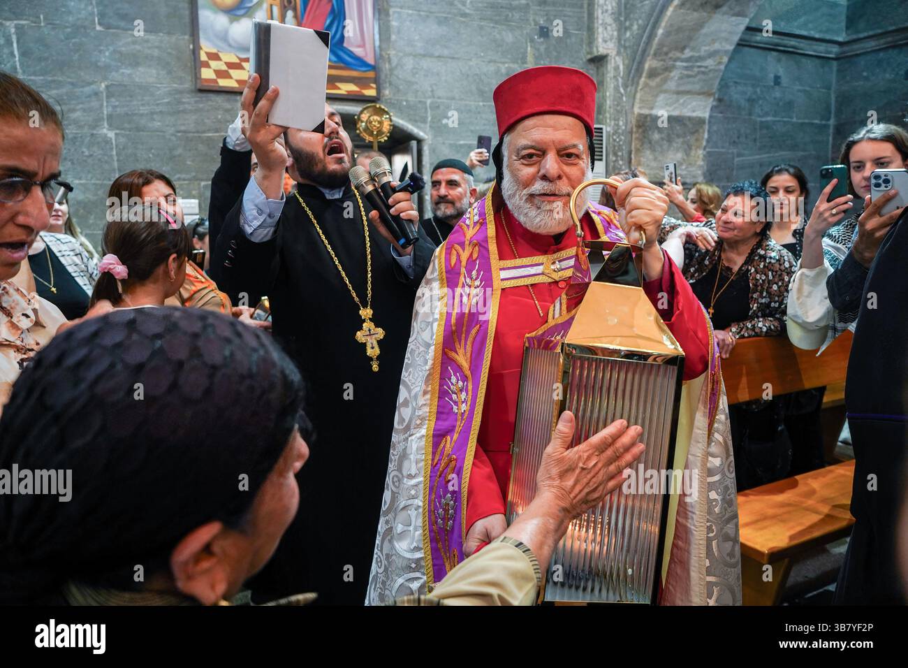 5 mai 2024, Ninive, Irak : une chrétienne orthodoxe syriaque touche le feu Saint lors de la cérémonie de son arrivée au monastère Mar Matti près de Mossoul. Les chrétiens orthodoxes orientaux croient que le «feu Saint» émane de l'intérieur de la tombe du Christ à l'intérieur de l'église du Saint-Sépulcre le samedi Saint à Jérusalem. Les croyants chrétiens orthodoxes orientaux marquent la semaine Sainte de Pâques en célébrant la crucifixion et la résurrection de Jésus-Christ. Le monde orthodoxe oriental célèbre le jour de Pâques selon l'ancien calendrier Julien. (Crédit image : © Ismael Adnan/SOPA images via ZUMA Banque D'Images