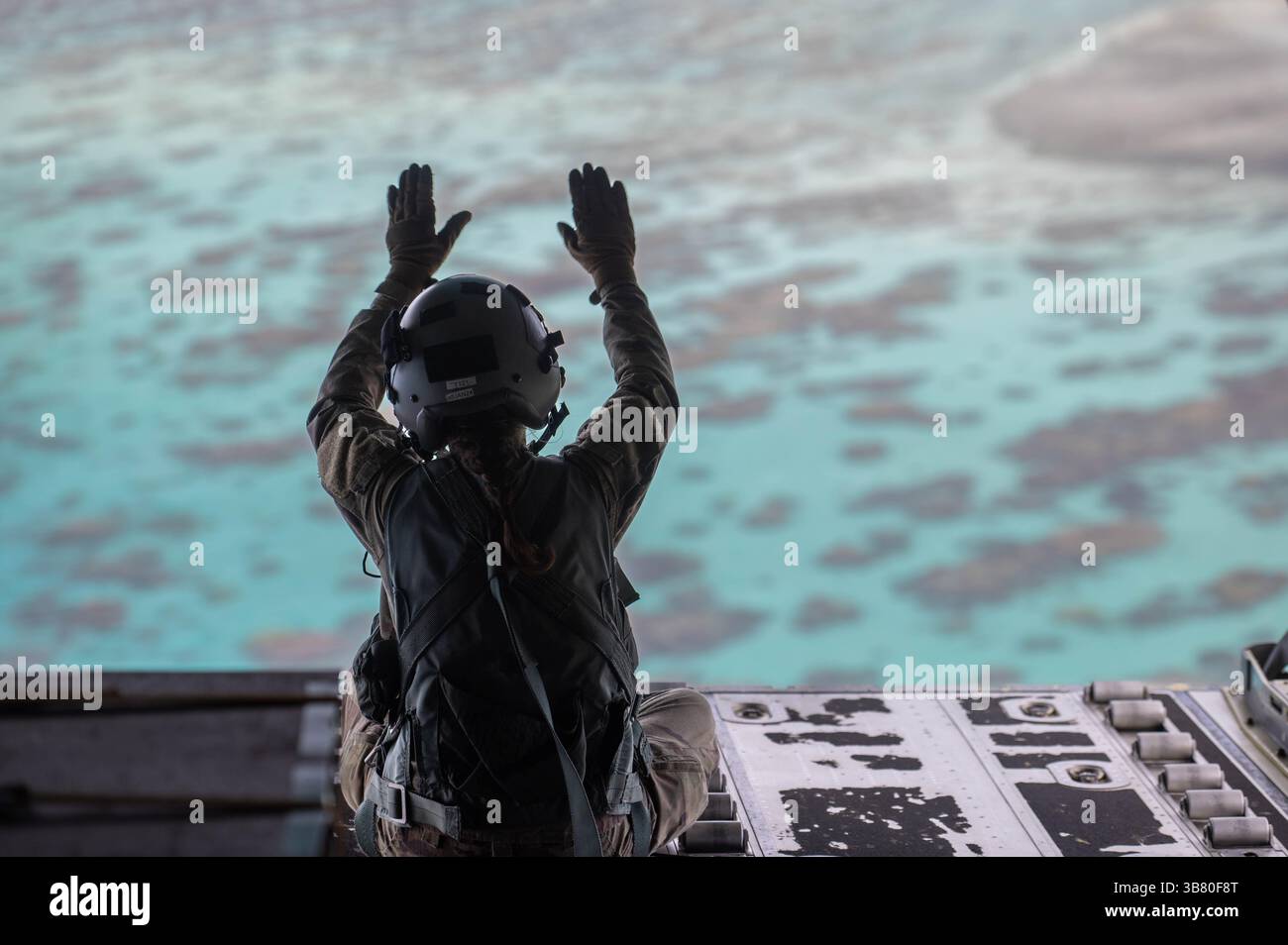 4 décembre 2023, atoll de Losap, Upper Mortlock Isla, État de Chuuk, États fédérés de Micronésie : Megan Irvin, maître de chargement de l'US Air Force Senior Airman, vagues après avoir largué des faisceaux humanitaires en parachute vers une lagune à partir d'un avion C-130J Super Hercules de l'US Air Force, lors de l'opération Christmas Drop, le 4 décembre 2023 dans l'atoll de Losap, dans les îles Upper Mortlock, Micronésie. L’opération Christmas Drop est la plus ancienne mission humanitaire et de secours en cas de catastrophe, livrant 71 000 livres de nourriture, de cadeaux et de fournitures pour aider les communautés insulaires éloignées du Pacifique Sud. (Crédit image : © Airman Allon Lapai Banque D'Images