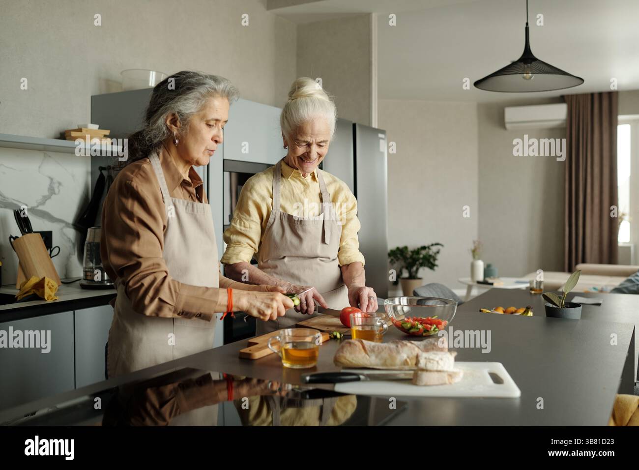 Les femmes âgées préparent un repas dans la cuisine moderne Banque D'Images