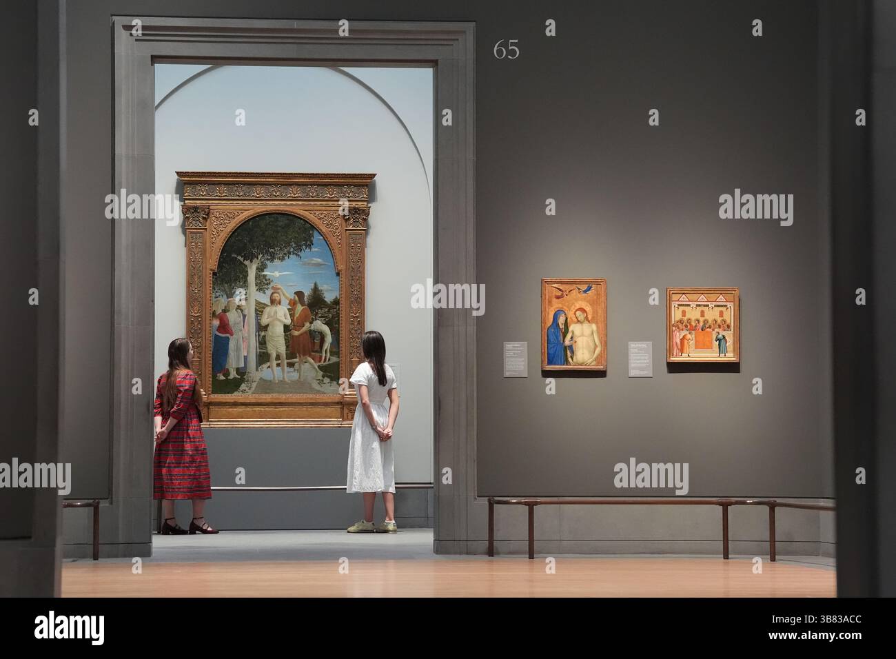 Les gens regardent le 'baptême du Christ' de Piero della Francesca exposé lors d'un aperçu de l'exposition CC Land : The Wonder of Art dans l'aile rénovée Sainsbury de la National Gallery de Londres, qui rouvre après deux ans de rénovation. Les modifications apportées à l'aile Sainsbury de la galerie comprennent une nouvelle entrée, des boutiques, des cafés, des fenêtres éclairées et un nouveau domaine public reliant l'espace à Trafalgar Square. À l'intérieur des galeries, la collection a été réexposée, avec plus de 1 000 œuvres d'art retraçant le développement de la peinture dans la tradition de l'Europe occidentale du 13 au 30 septembre Banque D'Images