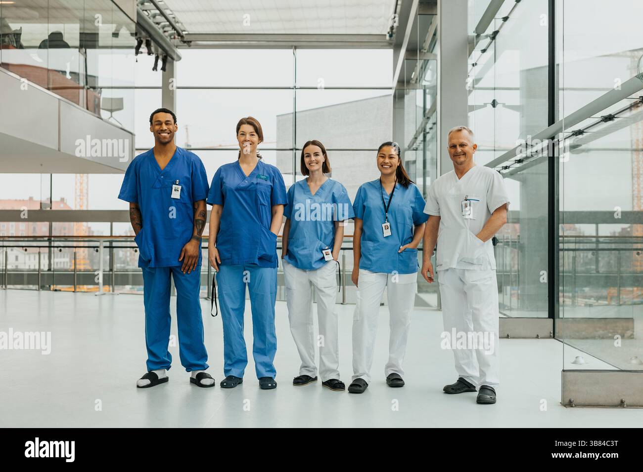 Portrait d'une équipe médicale multiraciale masculine et féminine debout côte à côte dans le couloir de l'hôpital Banque D'Images