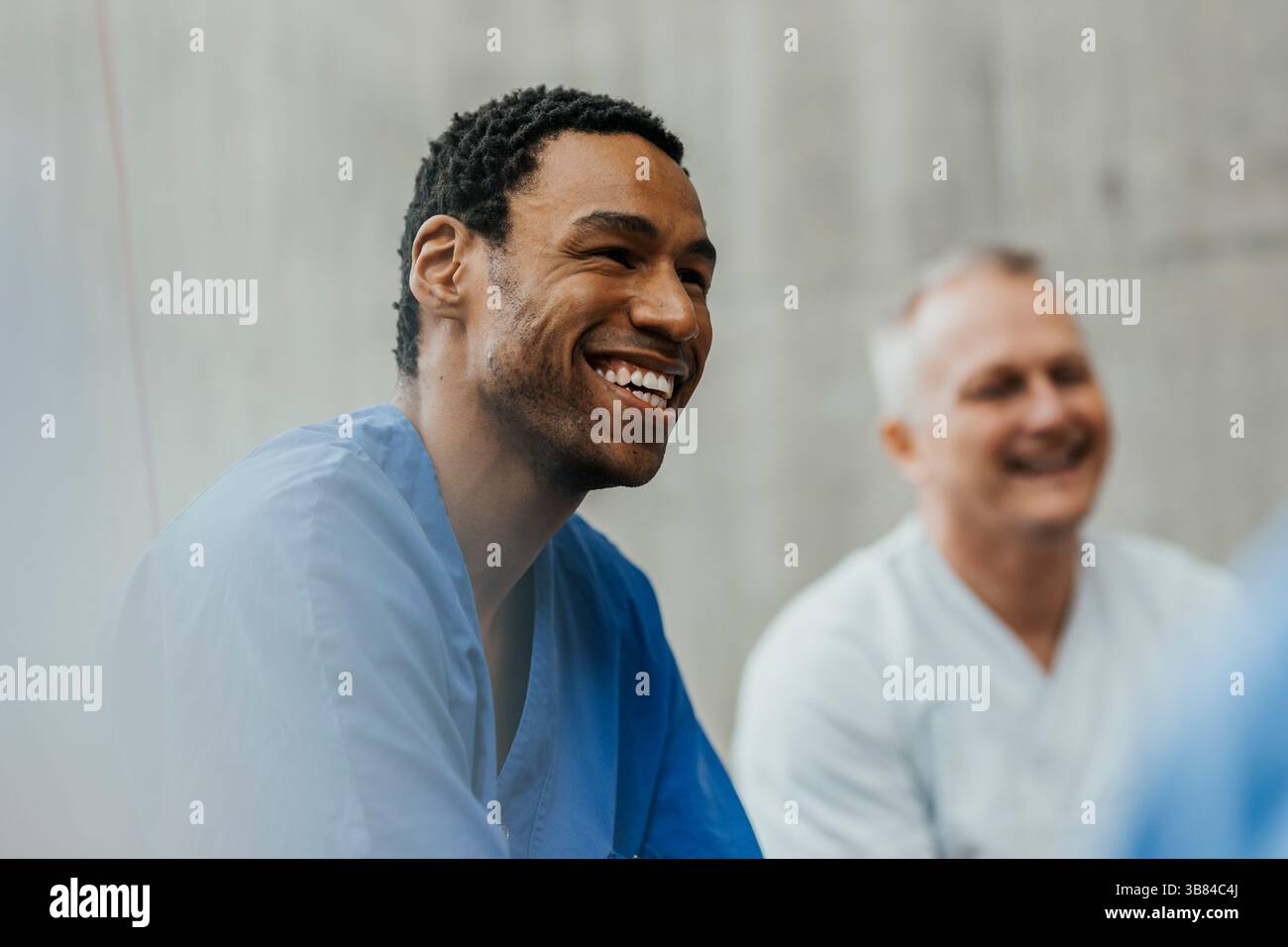 Heureux travailleur de santé masculin appréciant avec l'équipe médicale à l'hôpital Banque D'Images