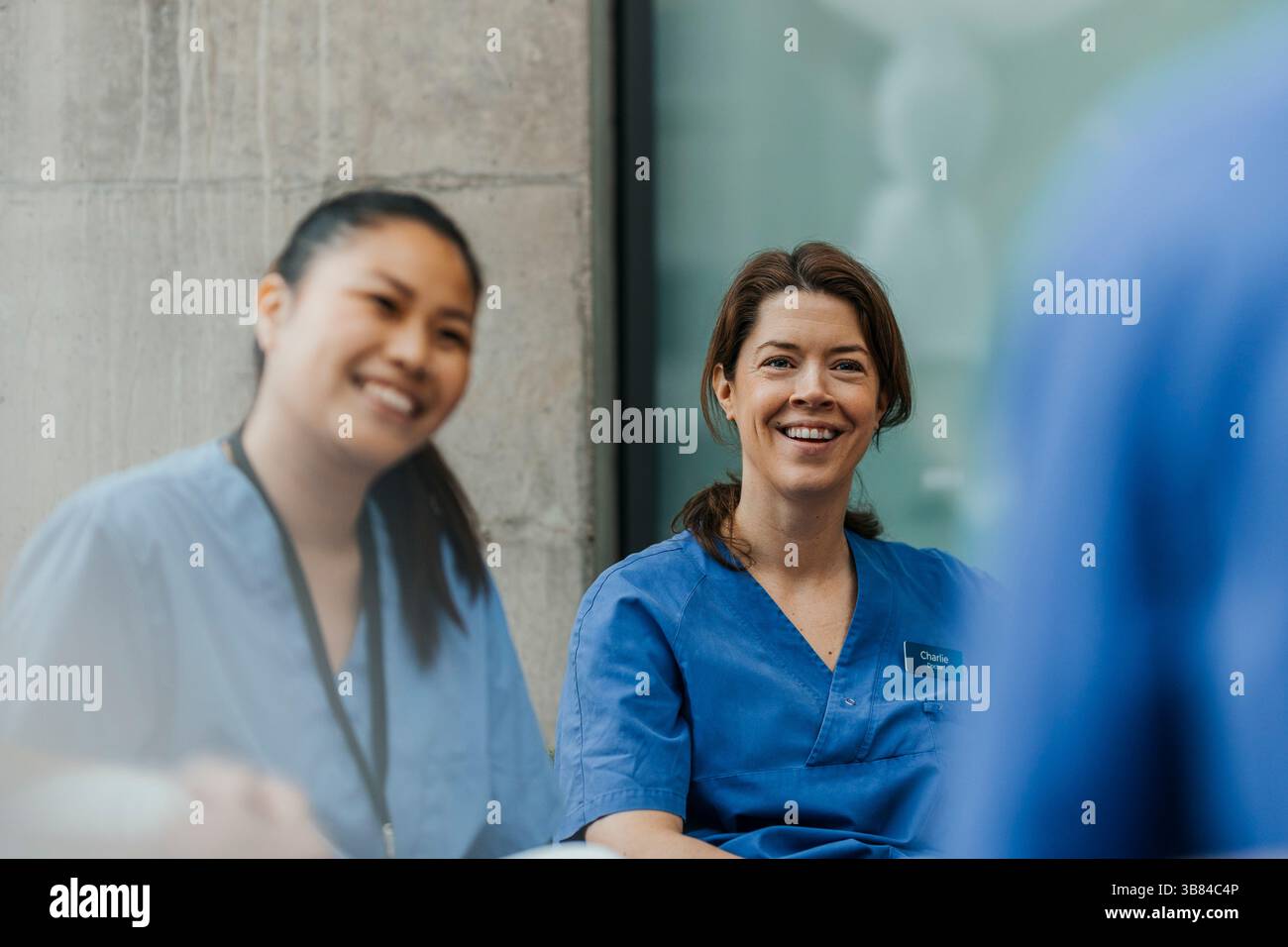 Femme heureuse médecin assise avec l'équipe médicale à l'hôpital Banque D'Images