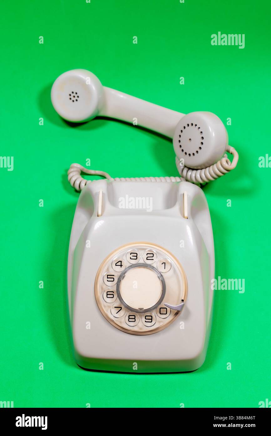Un téléphone de roulette antique sur une surface verte. Banque D'Images
