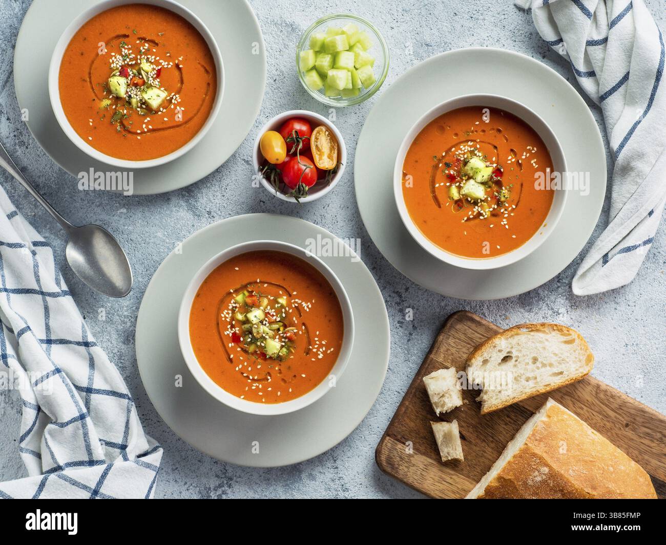 Soupe de gaspacho sur table en marbre blanc. Trois bols de purée espagnole traditionnelle à soupe froide gaspacho ou gazpacho sur fond gris clair ou marbre blanc Banque D'Images