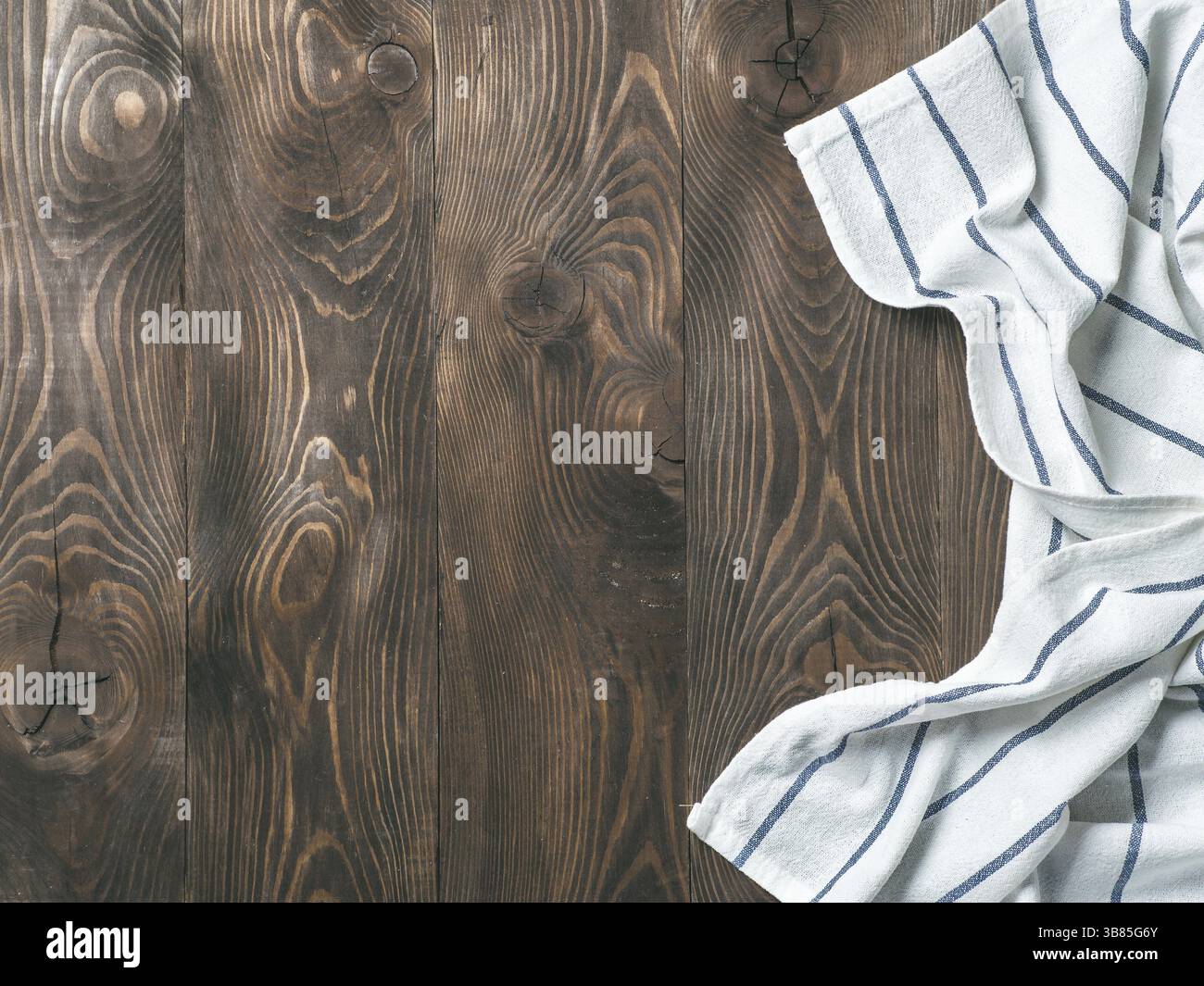 Vue de dessus de table en bois brun avec des draps ou des serviettes de cuisine nappes textiles. Nappe bleue sur bois marron foncé d'examen. L'espace de copie pour le texte. Ca Banque D'Images