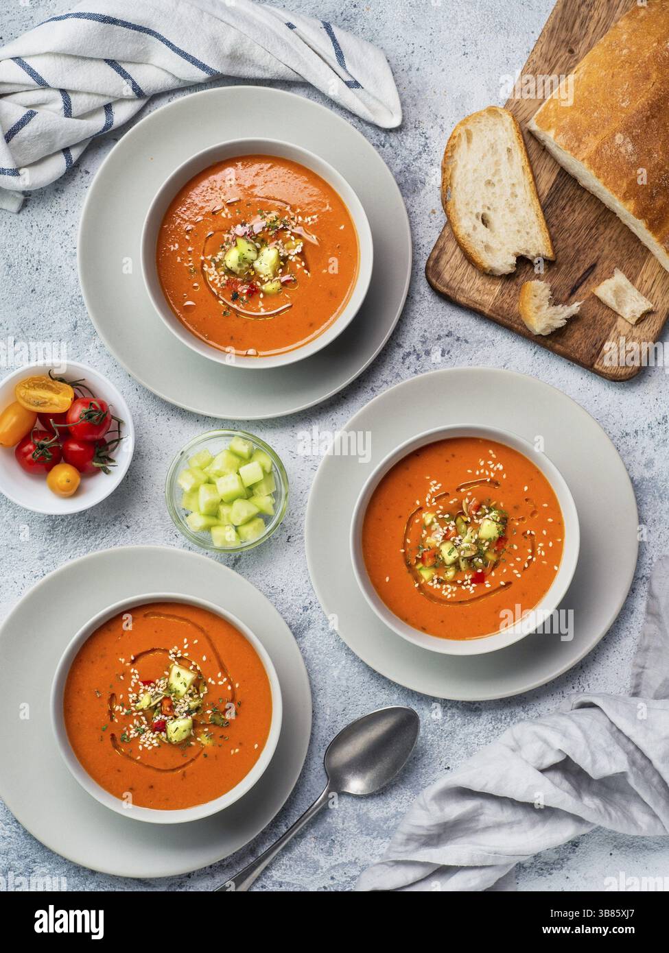Soupe de gaspacho sur table en marbre blanc. Trois bols de purée espagnole traditionnelle à soupe froide gaspacho ou gazpacho sur fond gris clair ou marbre blanc Banque D'Images