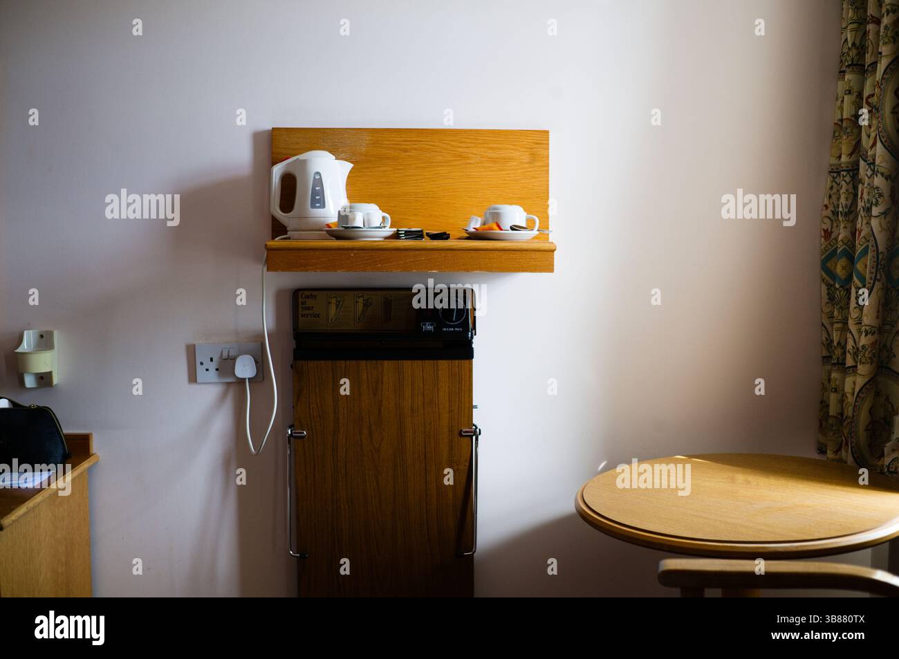 Chambre d'hôtel typique avec plateau thé et presse à pantalons Banque D'Images