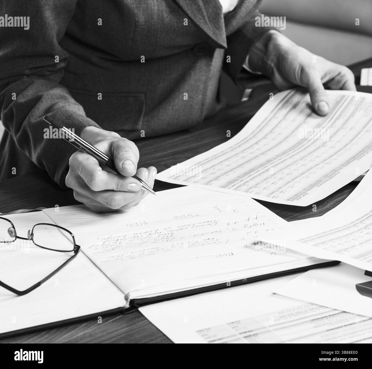 Gros plan d'une main féminine calculant, sur le bureau Banque D'Images