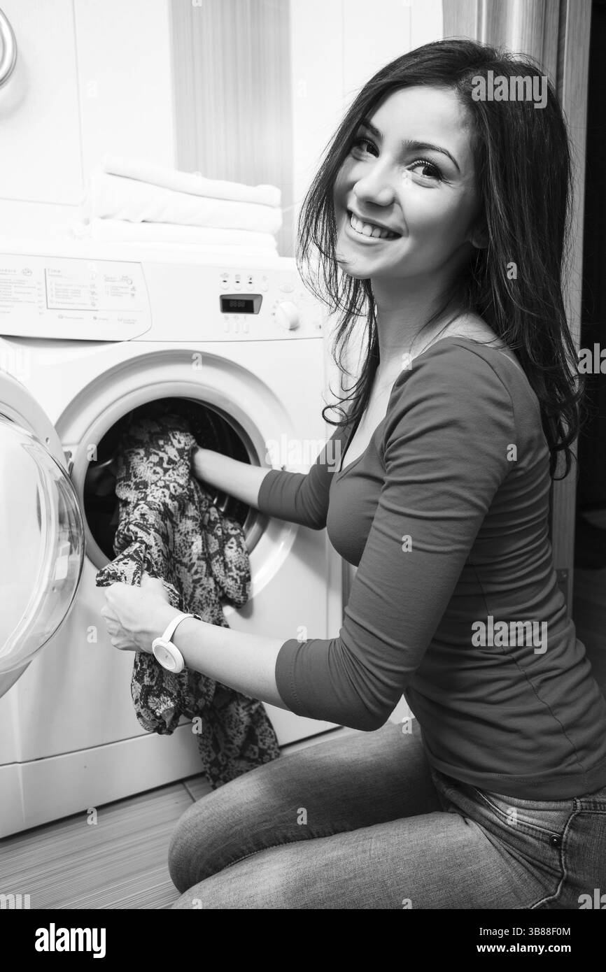 Close up of a young woman putting un tissu en machine à laver Banque D'Images