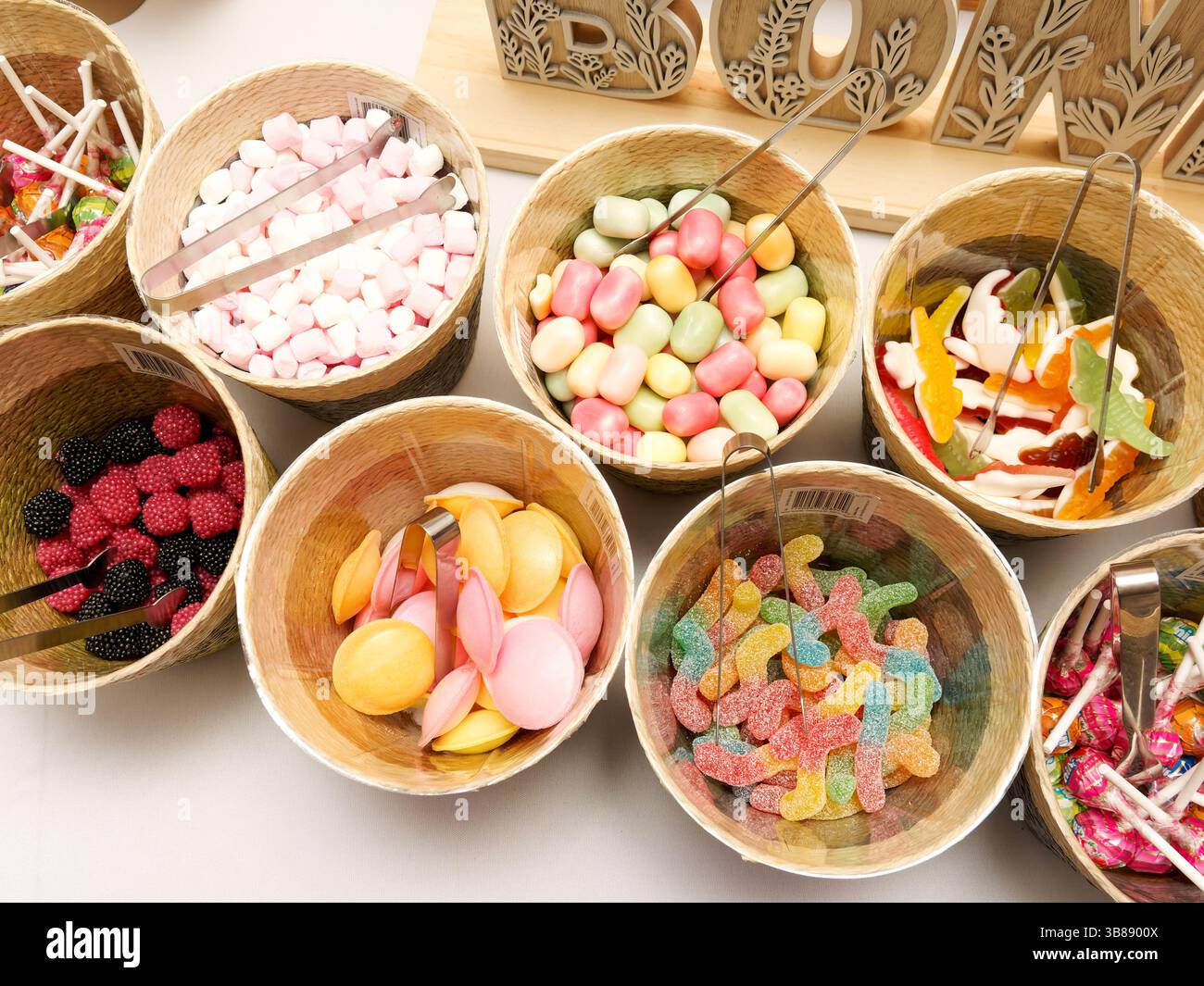 Bar à bonbons de mariage coloré avec des bonbons assortis dans des bocaux, magnifiquement arrangé pour les invités à profiter à la célébration de la réception. Banque D'Images Bar à bonbons de mariage coloré avec des bonbons assortis dans des bocaux, magnifiquement arrangé pour les invités à profiter à la célébration de la réception. Banque D'Images