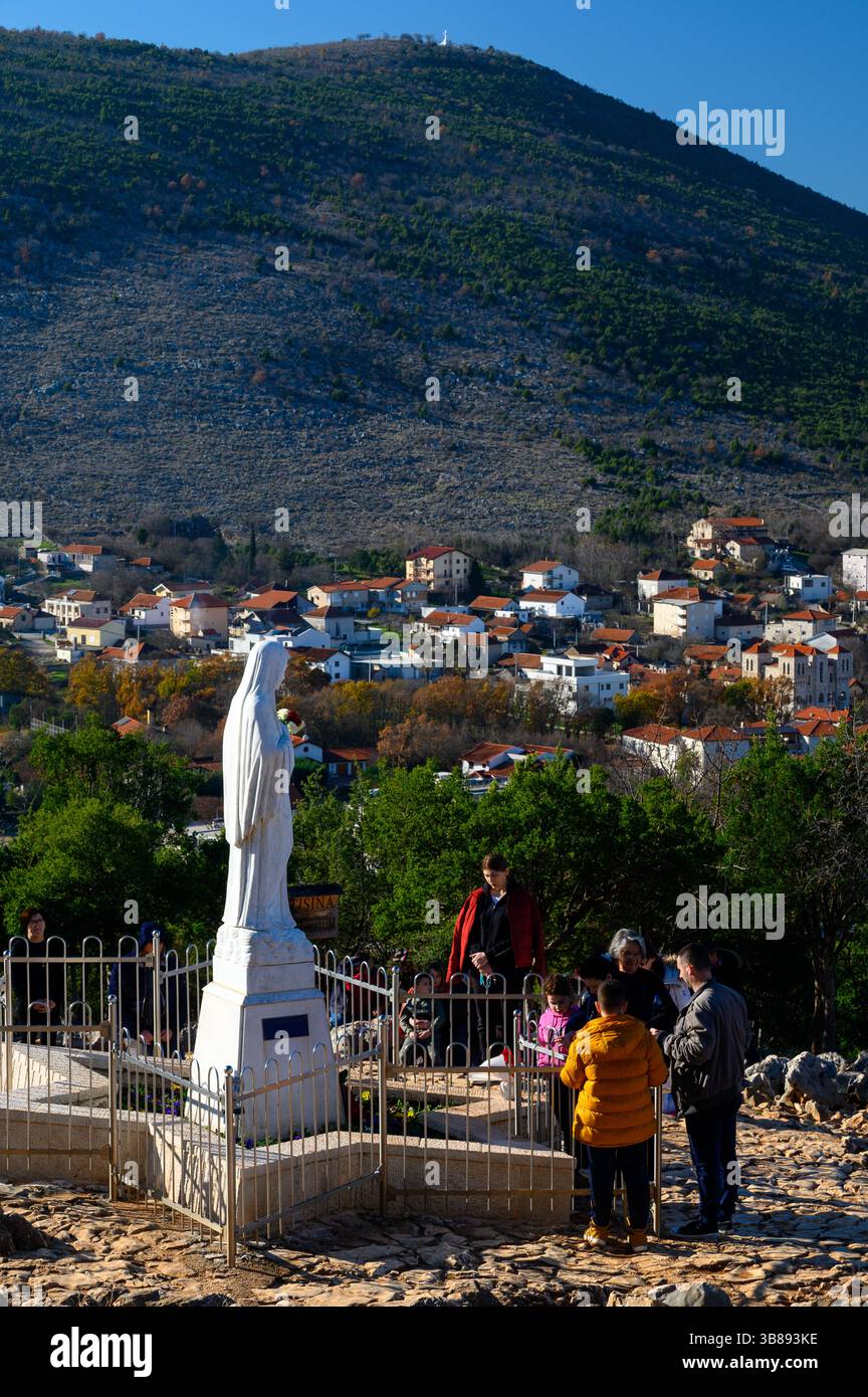Statue de la Bienheureuse Vierge Marie sur le mont Podbrdo, tandis que Križevac [la montagne de la Croix] est en arrière-plan. Medjugorje, Bosnie-Herzégovine. Banque D'Images