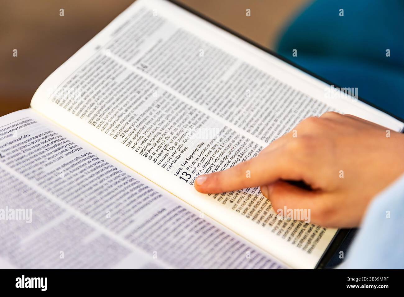 Gros plan et foyer peu profond de la main de l'enfant tout en lisant la Bible Banque D'Images