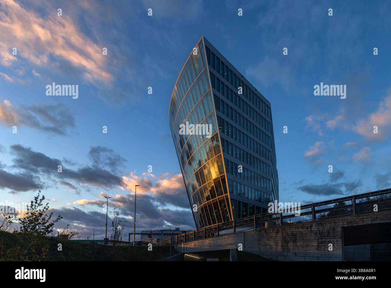 Kloten, Suisse - décembre 06. 2024 : le bureau moderne et l'architecture du complexe commercial The Circle à l'aéroport de Zurich avec le reflet du coucher du soleil Banque D'Images