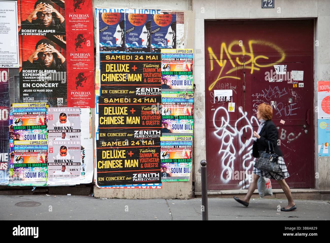 Piéton parisien dans la rue de Paris pssing par un mur plein d'annonces de concerts en 2014 Banque D'Images Piéton parisien dans la rue de Paris pssing par un mur plein d'annonces de concerts en 2014 Banque D'Images