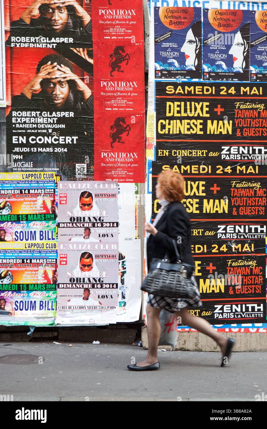 Piéton parisien dans la rue de Paris pssing par un mur plein d'annonces de concerts en 2014 Banque D'Images Piéton parisien dans la rue de Paris pssing par un mur plein d'annonces de concerts en 2014 Banque D'Images