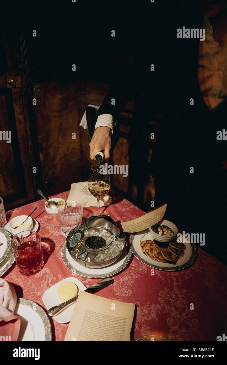 Élégant service de caviar raffiné avec vin blanc versé dans le restaurant de luxe Banque D'Images