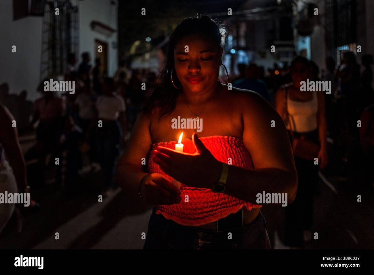 Un dévot catholique, membre d'une confrérie religieuse, tient une bougie allumée lors d'une procession pendant les célébrations de la semaine Sainte à Mompox, en Colombie. Banque D'Images