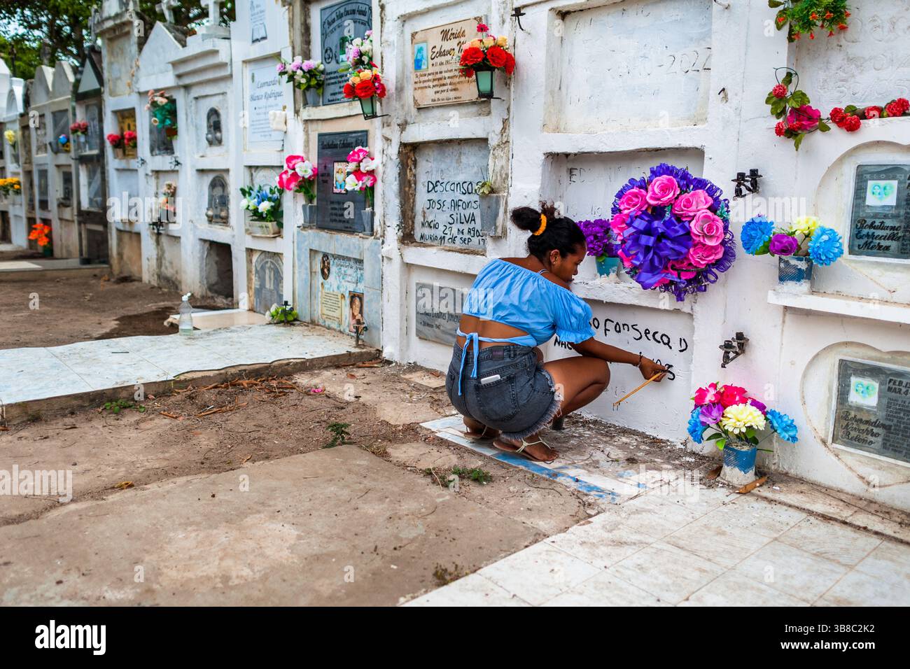 Une colombienne répare l'inscription dans le columbarium avant les célébrations de la semaine Sainte au cimetière de Mompox, en Colombie. Banque D'Images