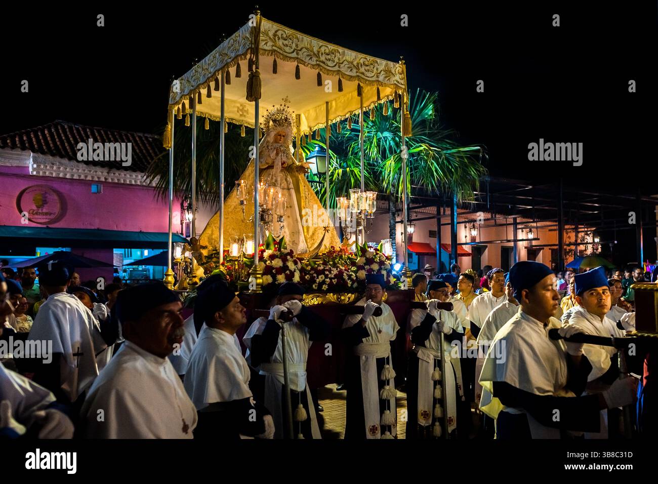 Nazarenos, membres pieux d'une confrérie religieuse, portent un char (paso) pendant la procession de la semaine Sainte à Mompox, en Colombie. Banque D'Images