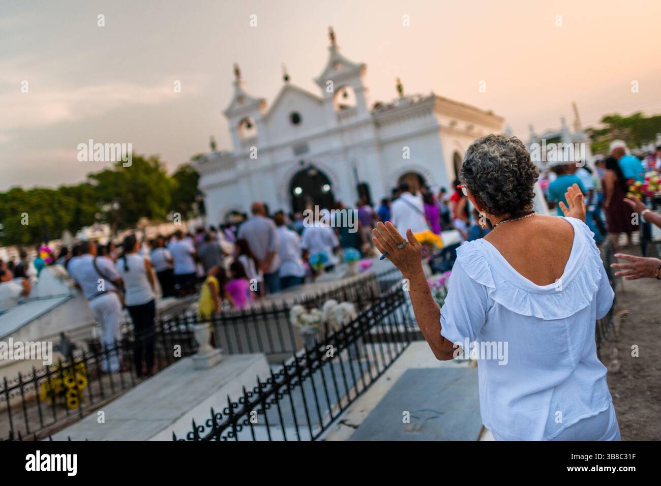 Une colombienne prie pendant la messe du soir dans le cadre des célébrations de la semaine Sainte au cimetière de Mompox, en Colombie. Banque D'Images