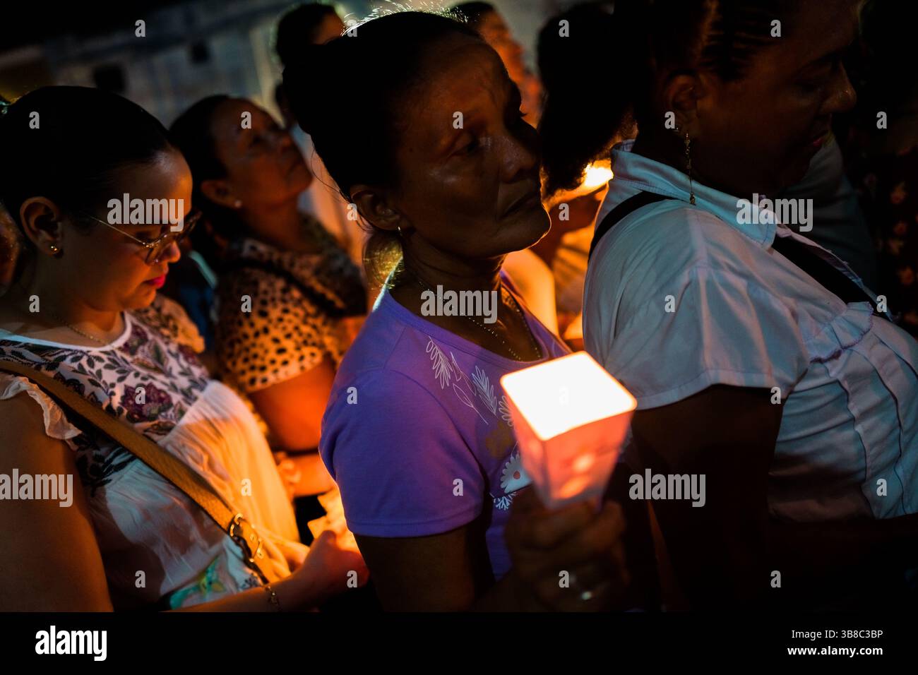Les femmes dévotes catholiques, membres d'une confrérie religieuse, portent des bougies allumées pendant la procession de la semaine Sainte à Mompox, en Colombie. Banque D'Images