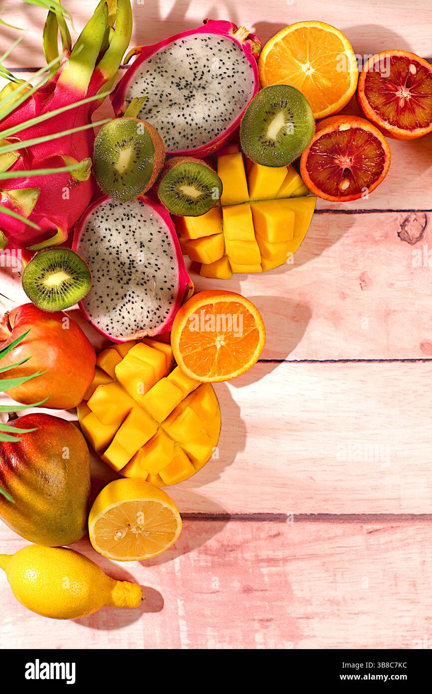 Nourriture saine végétalienne pour perdre du poids, carte publicitaire pour un magasin. Fruit du dragon, pitaya, mangue et oranges sur une table ensoleillée. Bannière d'été avec tropica Banque D'Images