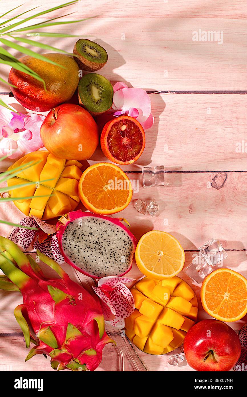 Nourriture saine végétalienne pour perdre du poids, carte publicitaire pour un magasin. Fruit du dragon, pitaya, mangue et oranges sur une table ensoleillée. Bannière d'été avec tropica Banque D'Images