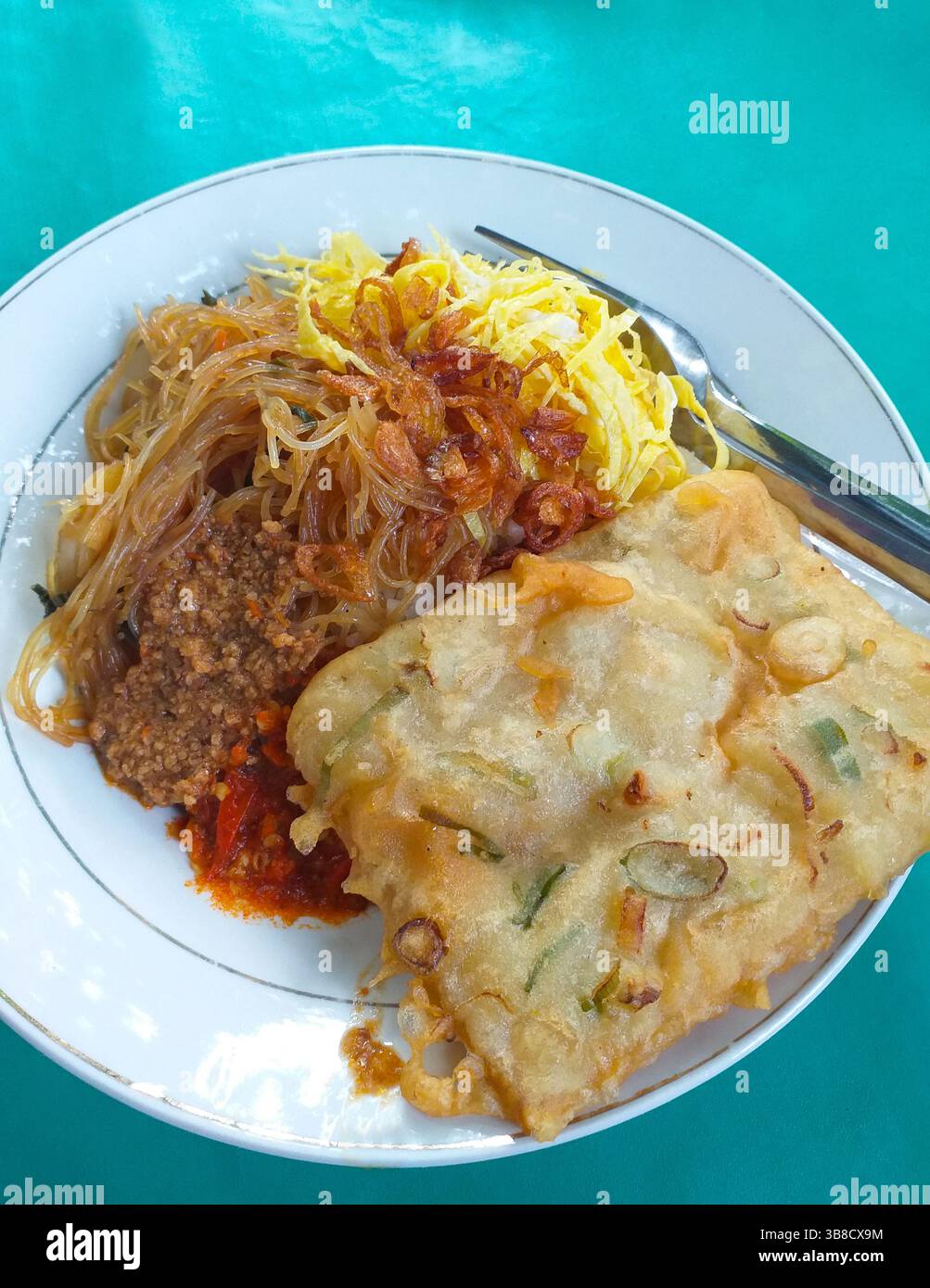 Cuisine indonésienne - Nasi uduk avec bihun goreng ou vermicelles frits, rendang sapi, tempe mendoan et omelette râpée. Banque D'Images