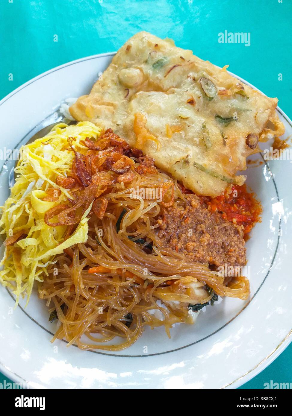 Cuisine indonésienne - Nasi uduk avec bihun goreng ou vermicelles frits, rendang sapi, tempe mendoan et omelette râpée. Banque D'Images