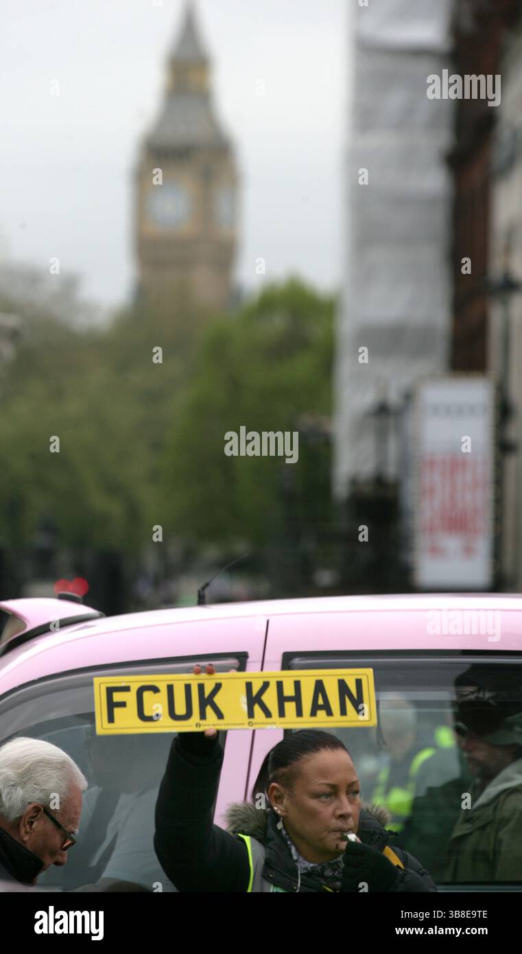 27 avril 2024, Londres, Royaume-Uni : une manifestante tient une pancarte montrant son mécontentement envers le maire avec les chambres du Parlement en arrière-plan. Les manifestants se rassemblent à Trafalgar Square à Londres pour protester contre la charge de la zone à ultra-faibles émissions (ULEZ) du maire de Sadiq Khan. Il a été introduit pour la première fois en 2019 et la zone a été élargie en 2023. Les voitures non conformes doivent payer pour entrer dans la zone et les entreprises disent que la taxe leur nuit. Les manifestants pensent également que les chiffres de la pollution atmosphérique sont faussés pour soutenir des restrictions toujours plus onéreuses pour les automobilistes de Londres (crédit image : © Mar Banque D'Images