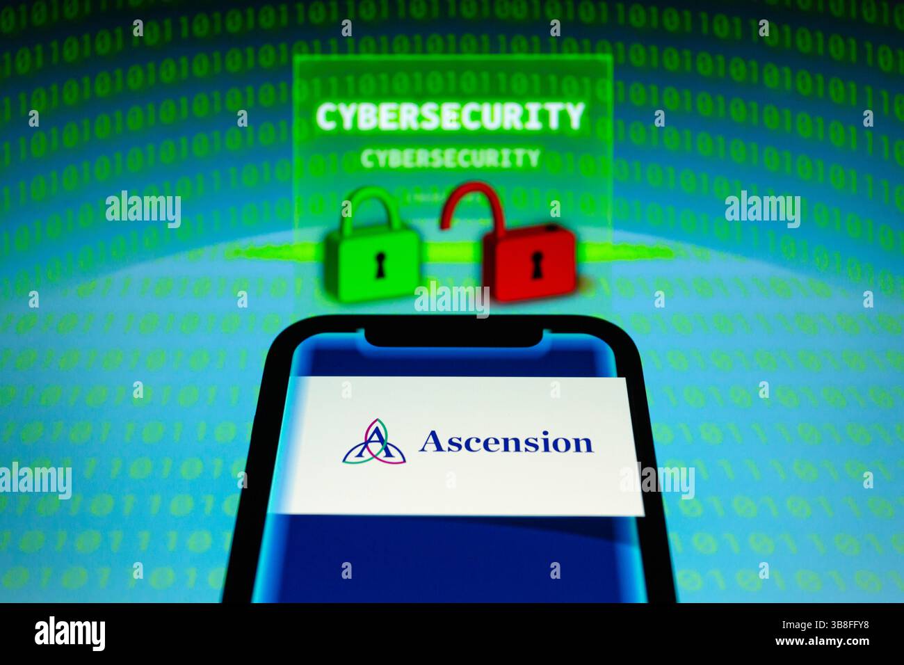 9 mai 2024, Asuncion, Paraguay : logo d'Ascension, un système de santé basé aux États-Unis, est affiché sur un smartphone devant le mot ''cybersécurité'', représentation visuelle de cadenas et de chiffres binaires. Ascension a déclaré ''mercredi 8 mai, nous avons détecté une activité inhabituelle sur certains systèmes de réseau de technologie, que nous croyons maintenant être due à un événement de cybersécurité. Pour le moment, nous continuons d'enquêter sur la situation. Nous avons réagi immédiatement, lancé notre enquête et activé nos efforts d'assainissement. L'accès à certains systèmes a été interrompu au fur et à mesure que ce processus se poursuit. (Crédit Imag Banque D'Images