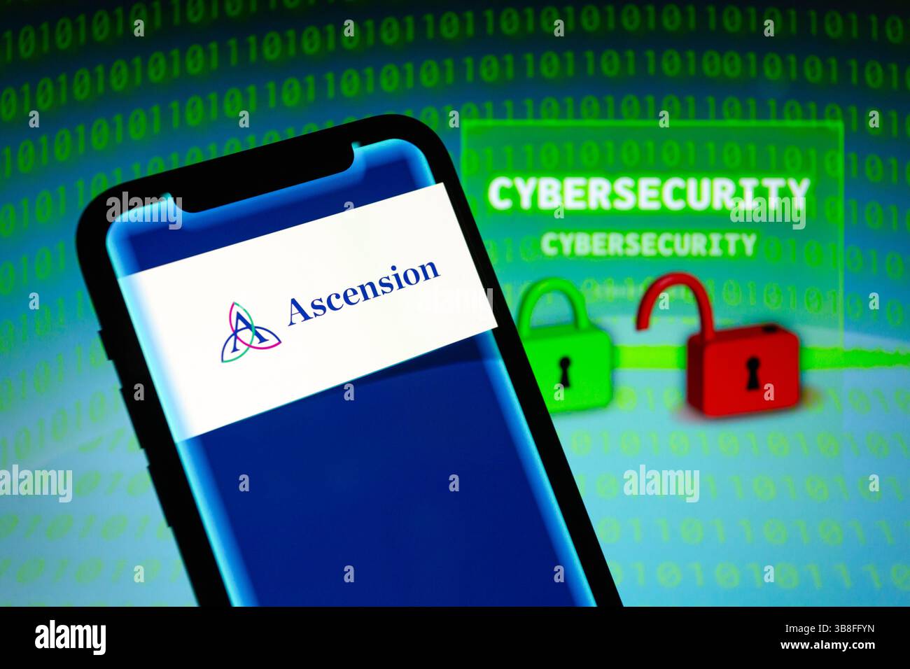 9 mai 2024, Asuncion, Paraguay : logo d'Ascension, un système de santé basé aux États-Unis, est affiché sur un smartphone devant le mot ''cybersécurité'', représentation visuelle de cadenas et de chiffres binaires. Ascension a déclaré ''mercredi 8 mai, nous avons détecté une activité inhabituelle sur certains systèmes de réseau de technologie, que nous croyons maintenant être due à un événement de cybersécurité. Pour le moment, nous continuons d'enquêter sur la situation. Nous avons réagi immédiatement, lancé notre enquête et activé nos efforts d'assainissement. L'accès à certains systèmes a été interrompu au fur et à mesure que ce processus se poursuit. (Crédit Imag Banque D'Images