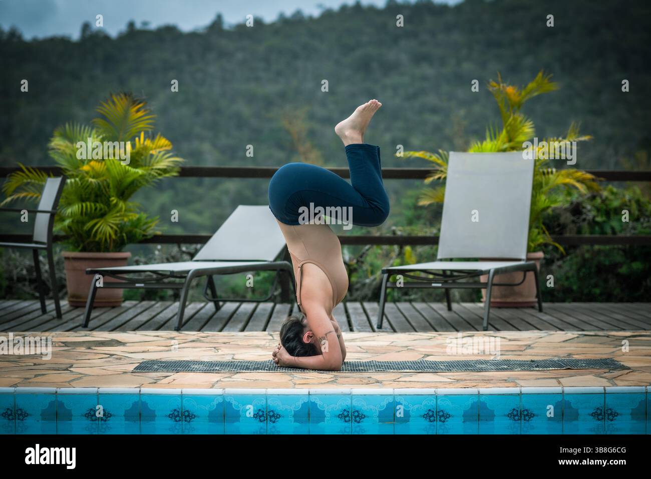 Femme pratiquant avant-bras Stand Yoga pose près de la piscine Banque D'Images