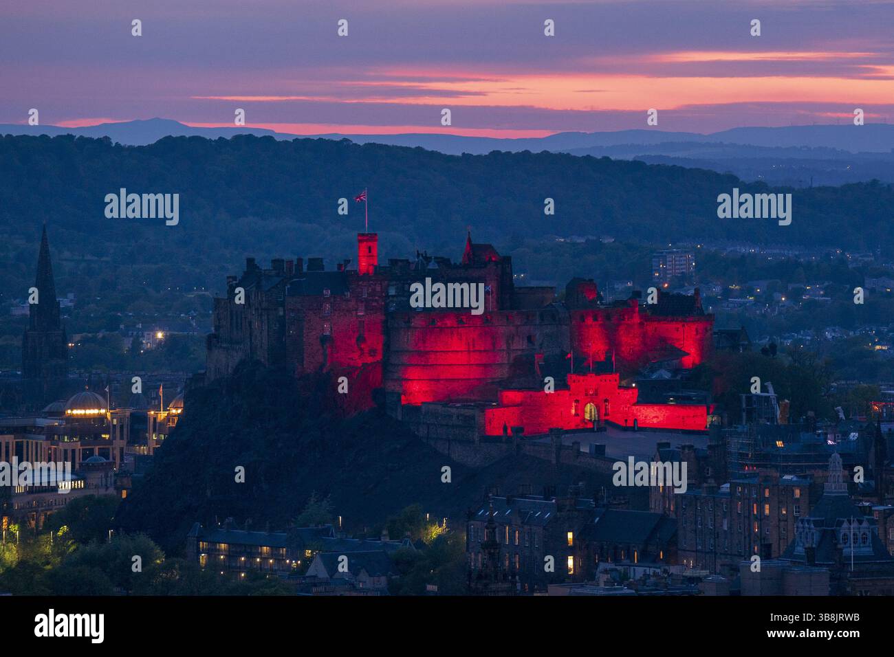 Photo datée du 06/05/25 du château d'Édimbourg illuminé en rouge alors que des monuments historiques à travers le Royaume-Uni sont illuminés pour le 80e anniversaire du VE Day. L’Écosse s’apprête à rendre hommage à ses héros de guerre avec des événements qui se déroulent dans tout le pays pour marquer le 80e anniversaire de la Journée VE. Date d'émission : jeudi 8 mai 2025. Banque D'Images