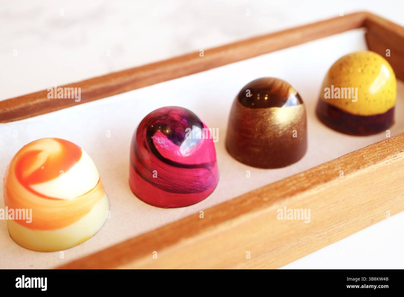 Quatre de beaux bonbons au chocolat dans diverses couleurs et motifs Banque D'Images